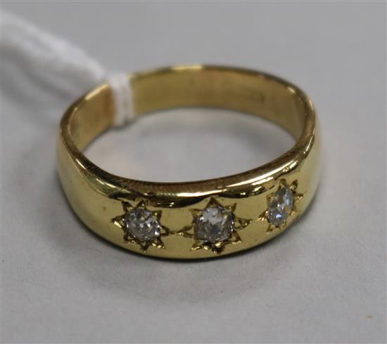 A gentlemans 18ct gold and gypsy set three stone diamond ring, size V.